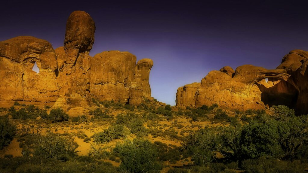 Explore stunning sandstone rock formations at Arches National Park under a clear sky.